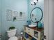 Charming powder room featuring unique wall decor, stylish vanity, and decorative turquoise accents at 25519 Hawks Run Ln, Sorrento, FL 32776
