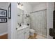 Cozy bathroom with a patterned shower curtain, white vanity, and classic fixtures at 25519 Hawks Run Ln, Sorrento, FL 32776