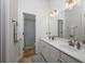 Bright bathroom with a double sink vanity, neutral tile floor, and access to a shower/tub combo at 25519 Hawks Run Ln, Sorrento, FL 32776