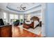 Spacious bedroom featuring a unique wood accent wall, stylish ceiling, and hardwood floors at 25519 Hawks Run Ln, Sorrento, FL 32776
