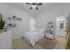 Simple bedroom with a ceiling fan, white walls, and doorway leading to a bathroom at 25519 Hawks Run Ln, Sorrento, FL 32776