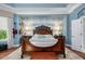 Bedroom with a beautiful accent wall, wood floors, decorative lighting, and an ornate, carved wooden bed at 25519 Hawks Run Ln, Sorrento, FL 32776