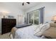 Bright bedroom featuring a ceiling fan, window with patterned curtains, and easy access to an ensuite bathroom at 25519 Hawks Run Ln, Sorrento, FL 32776