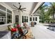 Inviting covered patio with stylish seating, ceiling fan, and views of the landscaped backyard and pool area at 25519 Hawks Run Ln, Sorrento, FL 32776