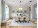 Dining room with travertine tile, wainscoting, and a large window with curtains at 25519 Hawks Run Ln, Sorrento, FL 32776