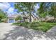 Beautiful home featuring manicured lawn, stone accents, mature trees, and driveway with garage at 25519 Hawks Run Ln, Sorrento, FL 32776
