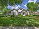 Beautiful home with stone accents, arched windows, manicured lawn, and lush landscaping for great curb appeal at 25519 Hawks Run Ln, Sorrento, FL 32776