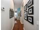 Inviting hallway with hardwood floors, decorative art, and framed photos adding warmth and character at 25519 Hawks Run Ln, Sorrento, FL 32776