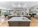 Bright, open kitchen and living area with large island, modern lighting, and a pool table on the left at 25519 Hawks Run Ln, Sorrento, FL 32776
