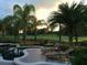 Resort-style pool area with lounge chairs, lush landscaping, and views of the manicured golf course at 25519 Hawks Run Ln, Sorrento, FL 32776