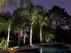 Inviting pool area with elegant lighting and lush landscaping, ideal for nighttime relaxation at 25519 Hawks Run Ln, Sorrento, FL 32776