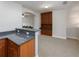 Open wet bar area with dark granite countertops, wooden cabinets, and a view of the adjacent living space at 25519 Hawks Run Ln, Sorrento, FL 32776