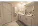 Bathroom featuring dual sinks, white cabinets, and an over-sized mirror at 2825 Muller Oak Loop, Ocoee, FL 34761