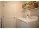 Convenient laundry room with white washer and dryer, shelves, and storage baskets at 2825 Muller Oak Loop, Ocoee, FL 34761
