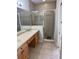 Bathroom features a double vanity with wooden cabinets and a glass-enclosed shower for a modern touch at 3181 Capri Isle Way, Orlando, FL 32835