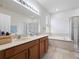 Bathroom featuring double sinks, a separate tub, and a glass-enclosed shower at 3505 Rhapsody St, St Cloud, FL 34772
