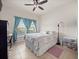 Bright bedroom featuring a ceiling fan and two large windows at 3505 Rhapsody St, St Cloud, FL 34772