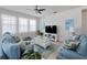Inviting living room showcasing a ceiling fan, blue furniture, and bright natural light at 3505 Rhapsody St, St Cloud, FL 34772