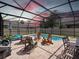 Enclosed pool featuring a screen enclosure, wooden chairs, and a stone pool deck for ultimate relaxation at 3505 Rhapsody St, St Cloud, FL 34772
