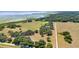 Expansive aerial view showcases the property's acreage, mature trees, and proximity to a lake at 3650 Lake Tohopekaliga Rd, St Cloud, FL 34772