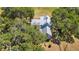 Aerial view of a home with a metal roof, surrounded by mature trees and lush landscaping at 3650 Lake Tohopekaliga Rd, St Cloud, FL 34772
