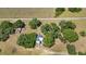 A scenic aerial view of a cozy home nestled among lush trees, featuring an expansive yard and a charming old outbuilding at 3650 Lake Tohopekaliga Rd, St Cloud, FL 34772