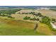 An aerial view reveals a vast, verdant landscape, dotted with trees and a distant home, offering a sense of peaceful seclusion at 3650 Lake Tohopekaliga Rd, St Cloud, FL 34772