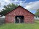 Rustic barn with weathered red paint on a large lot with trees and grass at 3650 Lake Tohopekaliga Rd, St Cloud, FL 34772
