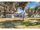 Quaint two-story home with a fenced yard, accessory building, and shady trees in a rural setting at 3650 Lake Tohopekaliga Rd, St Cloud, FL 34772