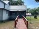 Exterior of home featuring a metal roof, porch access and lush surroundings at 3650 Lake Tohopekaliga Rd, St Cloud, FL 34772