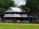 Charming two-story historic home with inviting screened porches and verdant yard at 3650 Lake Tohopekaliga Rd, St Cloud, FL 34772