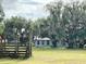 Exterior view of a light gray home surrounded by mature trees on a grassy lot at 3650 Lake Tohopekaliga Rd, St Cloud, FL 34772