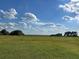 Expansive grassy lot with mature trees under a partly cloudy sky at 3650 Lake Tohopekaliga Rd, St Cloud, FL 34772