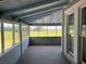 Covered porch featuring a wood floor and peaceful view of a meadow at 3650 Lake Tohopekaliga Rd, St Cloud, FL 34772