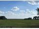 Beautiful waterfront view with expansive green fields under a partly cloudy sky at 3650 Lake Tohopekaliga Rd, St Cloud, FL 34772