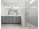 Bright bathroom featuring double sinks, white countertops, and a glass-enclosed shower at 4233 Mistwood St, Winter Garden, FL 34787