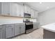 Stylish kitchen featuring gray cabinets, stainless steel appliances, and quartz countertops, combining functionality with modern design at 4233 Mistwood St, Winter Garden, FL 34787