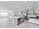 Open-concept kitchen with a large island, stainless steel appliances, and gray cabinetry, seamlessly connecting to the living area at 4233 Mistwood St, Winter Garden, FL 34787