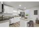 Bright kitchen features white cabinetry, stainless steel appliances, granite countertops and center island with bar stool seating at 4510 Douglas St, Sanford, FL 32771