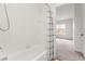 Bright bathroom showcasing a tiled shower-tub combo with a patterned curtain opening to a carpeted bedroom at 4897 Cypress Woods Dr # 6314, Orlando, FL 32811
