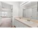 Bathroom with double sinks and a large mirror showcasing a door to bedroom at 4897 Cypress Woods Dr # 6314, Orlando, FL 32811
