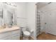 Well-lit bathroom featuring a single sink vanity, toilet, and a shower with a patterned shower curtain at 4897 Cypress Woods Dr # 6314, Orlando, FL 32811