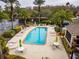 A shared community pool has ample seating and lush tropical landscaping on a small lake at 4897 Cypress Woods Dr # 6314, Orlando, FL 32811