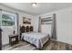 Well-lit bedroom with wood-look floors, comfortable bed, and picturesque outdoor views at 4908 Keith Pl, Orlando, FL 32808