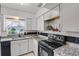 Bright kitchen with granite counters, white cabinets, and modern black appliances at 4908 Keith Pl, Orlando, FL 32808