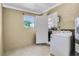 Laundry room featuring natural light and convenient access to both the kitchen and exterior at 4908 Keith Pl, Orlando, FL 32808