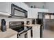 Efficient kitchen design with black appliances, including range and microwave, under bright white cabinetry at 505 Terrace Ridge Cir # 505, Davenport, FL 33896