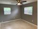 Comfortable bedroom with a ceiling fan, neutral carpet and paint, and two windows at 520 Ruffel St, Maitland, FL 32751