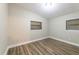 This is a bedroom that features hardwood floors and two large windows at 5201 Palisades Dr, Orlando, FL 32808