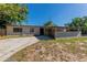 Single story home featuring a concrete driveway, covered carport, and neutral colored exterior in a sunny setting at 5201 Palisades Dr, Orlando, FL 32808
